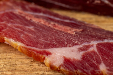 a piece of cured pork ham with thin layers of lard on the table