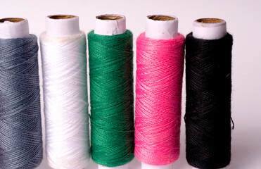 Colorful sewing thread set and needles isolated on background.