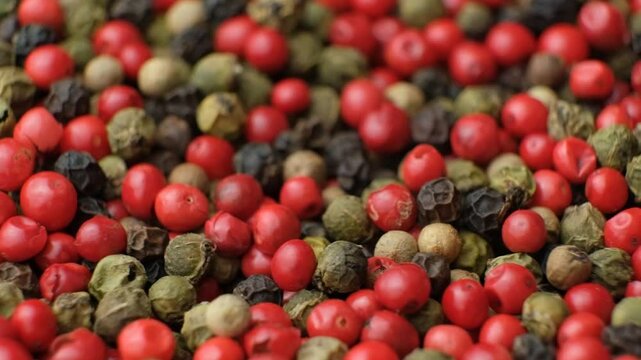 Rotation of a mixture of red, black, green and white peppercorns