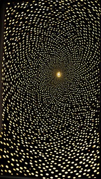 A captivating spiral of light created by intricate patterns in a dark space that draws the eye towards a central glow