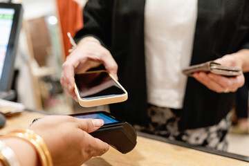 Customer Using Mobile Phone for Contactless Payment at Store