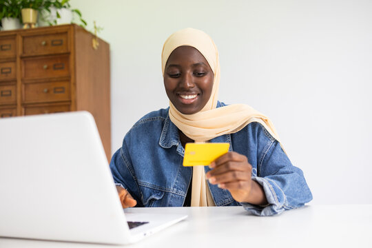 Black female doctor with credit card at workstation