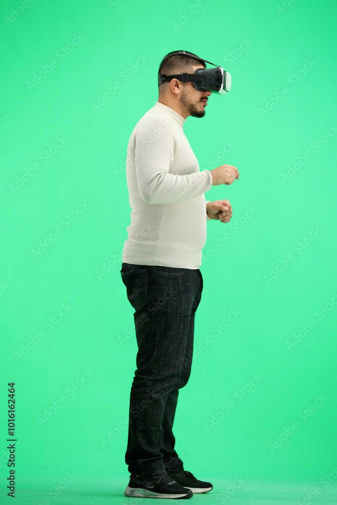 Canvas Prints Man, full-length, on a green background, wearing VR glasses