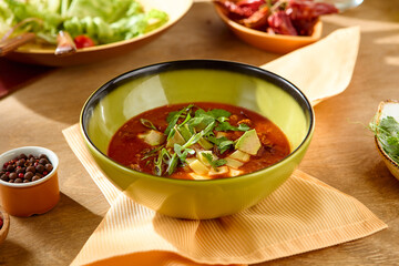Vibrant Bowl of Soup with Fresh Garnish in Warm Sunlight