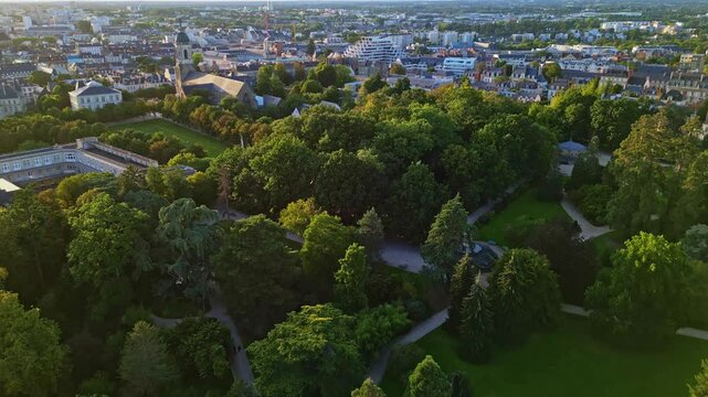 Parc du Thabor or Thabor park with Thabor church in background, Rennes, France. Aerial drone backward