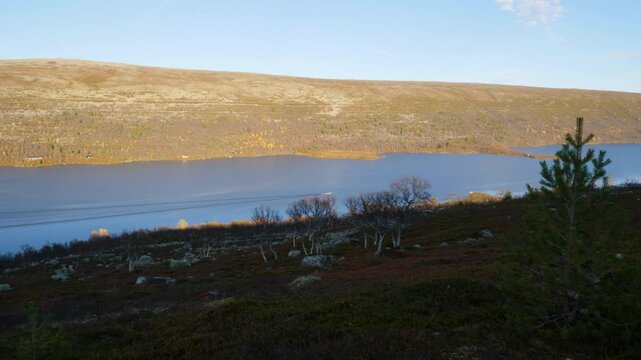 Boat in motion on a Swedish lake situated in alpine environment.