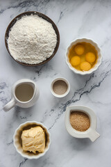 Ingredients for baking brioche bread laid out individually on a light background, top view.