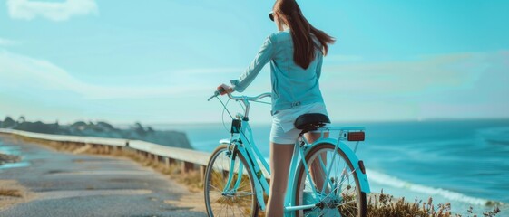 A woman in stylish attire pauses her bike along a coastal path, gazing at the serene ocean horizon, basking in the peaceful morning light.