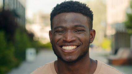 Close up male face happiness expression portrait African American happy smiling guy in city laugh funny reaction enjoy biracial man smile toothy white teeth dental service dentistry medicine outdoors