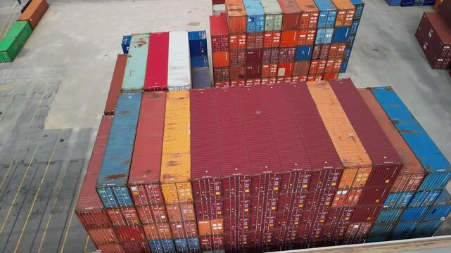 drone, vista su container colorati nei pressi di binari del treno
