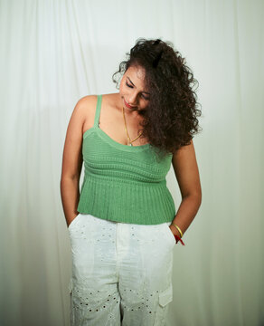 Fashion photoshoot of a young Indian woman with curly hair wearing a green dress.