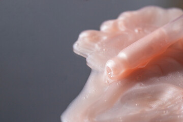 Close up of pipette with pink cosmetic serum smear. Collagen, enzyme, ceramide and peptides swatch. Skin care anti aging beauty face product.