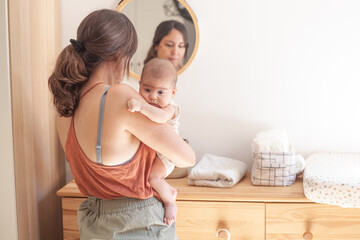 A woman holding a baby in front of a mirror