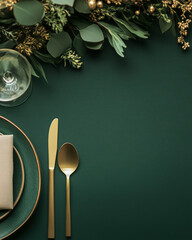 Elegant table setting with gold cutlery on dark green background