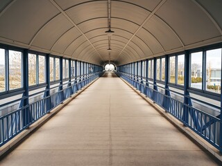 A covered walkway or bridge, characterized by its arched ceiling and blue railings