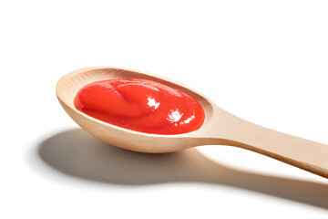 Wooden spoon of ketchup on white background, close up