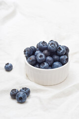Ripe blueberries in a bowl on white. Wild berries, Healthy eating