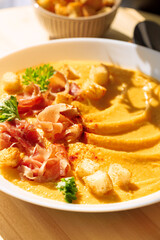 Pumpkin soup with jamon and croutons