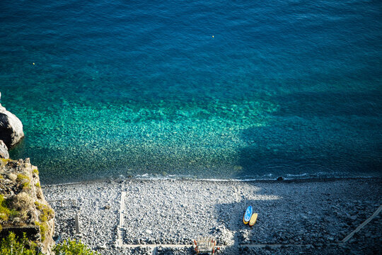 View form above of the crystal clear waters and volcanic stone beach of Spiaggia Dello Scario beach in Salina, Aeolian Islands. Mediterranean summer vacations.