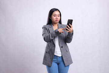 beautiful mature office woman pouting at mobile phone while touching, holding cellphone wearing grey suit isolated on white background. for technology, lifestyle, shopping, transaction content