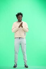 A man, full-length, on a green background, claps