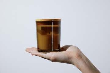 Person holding glass of tea with tea cup word on white background