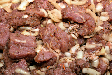 Pork meat is cut into pieces and marinated in spices before cooking.