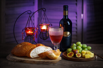 Challah bread, shabbat wine on the kitchen table. Traditional Jewish Shabbat ritual. Shabbat Shalom.