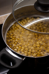 Close up of the process of cooking chickpeas to make hummus in a saucepan