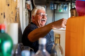 Elderly man smiling cheerfully in a cozy kitchen.