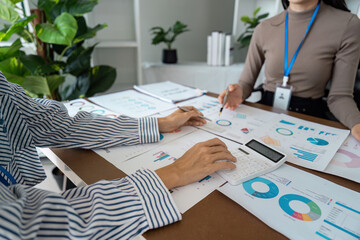 Collaborative Business Meeting with Charts and Calculator in a Modern Office Setting