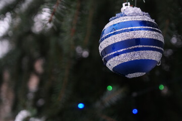 Fototapeta premium Christmas tree decoration blue ball with white stripes