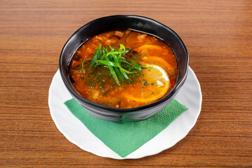 Russian soup Solyanka on wooden table side view