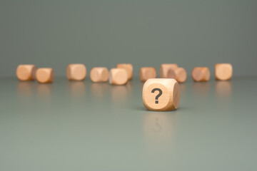 Wooden Blocks arranged on a vibrant Green Background featuring a prominent Question Mark