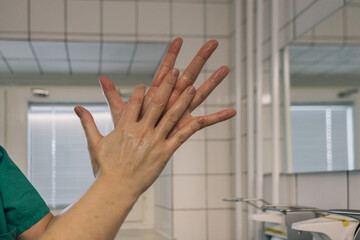 Hands of an unrecognizable doctor disinfecting his hands