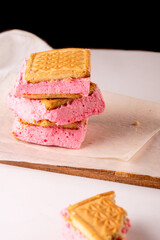 A delicious strawberry cream sandwich cookie paired with a cup of tea.