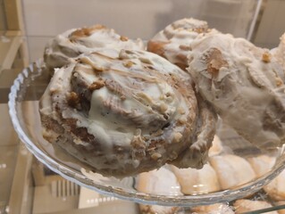 Cinnamon rolls with cream . Three cream buns lying on a plate in a cafe shop window
