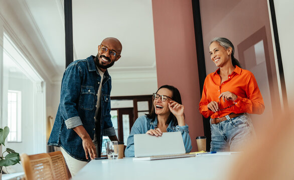 Creatives and freelancers collaborating in a modern, colorful office boardroom