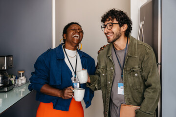 Candid moment: Employees at work sharing a joyful coffee break in the office, fostering friendship...