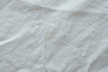 Grey textile napkin in white color as background. Folded decorative kitchen cotton towel