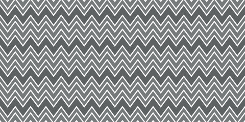 seamless pattern with zigzag lines forming geometric ornament in gray colors. chevron pattern