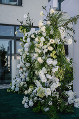 Naklejka premium Decor details closeup. Location for luxury wedding ceremony. Arch decorated white flowers, greens, greenery. Trendy decor in backyard. Celebration baptism concept. Birthday party reception.