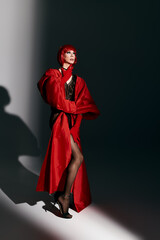 An attractive drag queen showcases confidence and style in a striking red outfit.