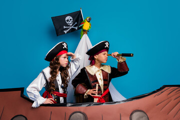 Photo of lovely two little kids explore spyglass dressed pirates costumes birthday party playing...