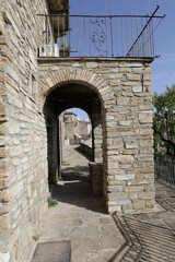 Obraz premium A small street among the old houses of a Guardia Perticara, small town in Basilicata, Italy.