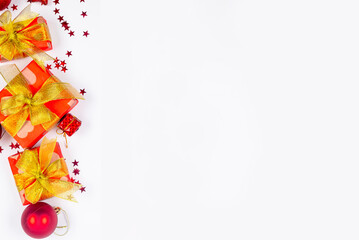 Red and gold christmas baubles, red gift boxes at white background. Merry Christmas greeting card,