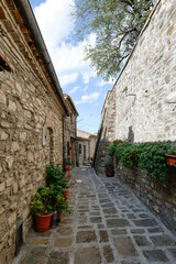 Naklejka premium A small street among the old houses of a Guardia Perticara, small town in Basilicata, Italy.