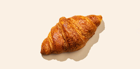 Fresh croissants on yellow  background with shadow. Creative layout and concept of healthy food and french breakfast.