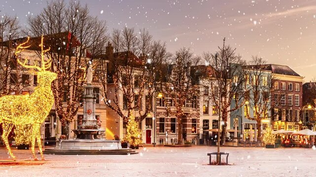 Winter view with snowfall of the central historic square with bars and restaurants in the ancient city center of Deventer, The Netherlands