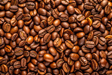 Fototapeta premium Rich roasted coffee beans create warm and inviting texture, perfect for coffee lovers. deep brown hues and varied shapes add to visual appeal of this delightful scene